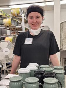 woman in hair net smiling in kitchen