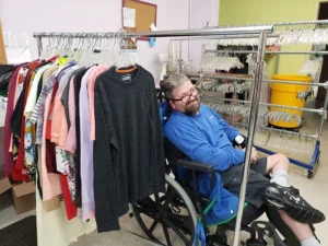 Man in wheelchair working with clothing