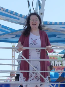 Lady smiling at camera waiting for fair ride.