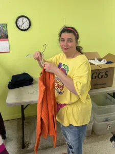 Woman putting shirt on hanger.